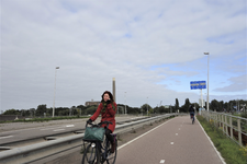 853552 Afbeelding van een fietsende vrouw op het fietspad naast de Vleutensebaan te Utrecht, bellend met een mobiele ...